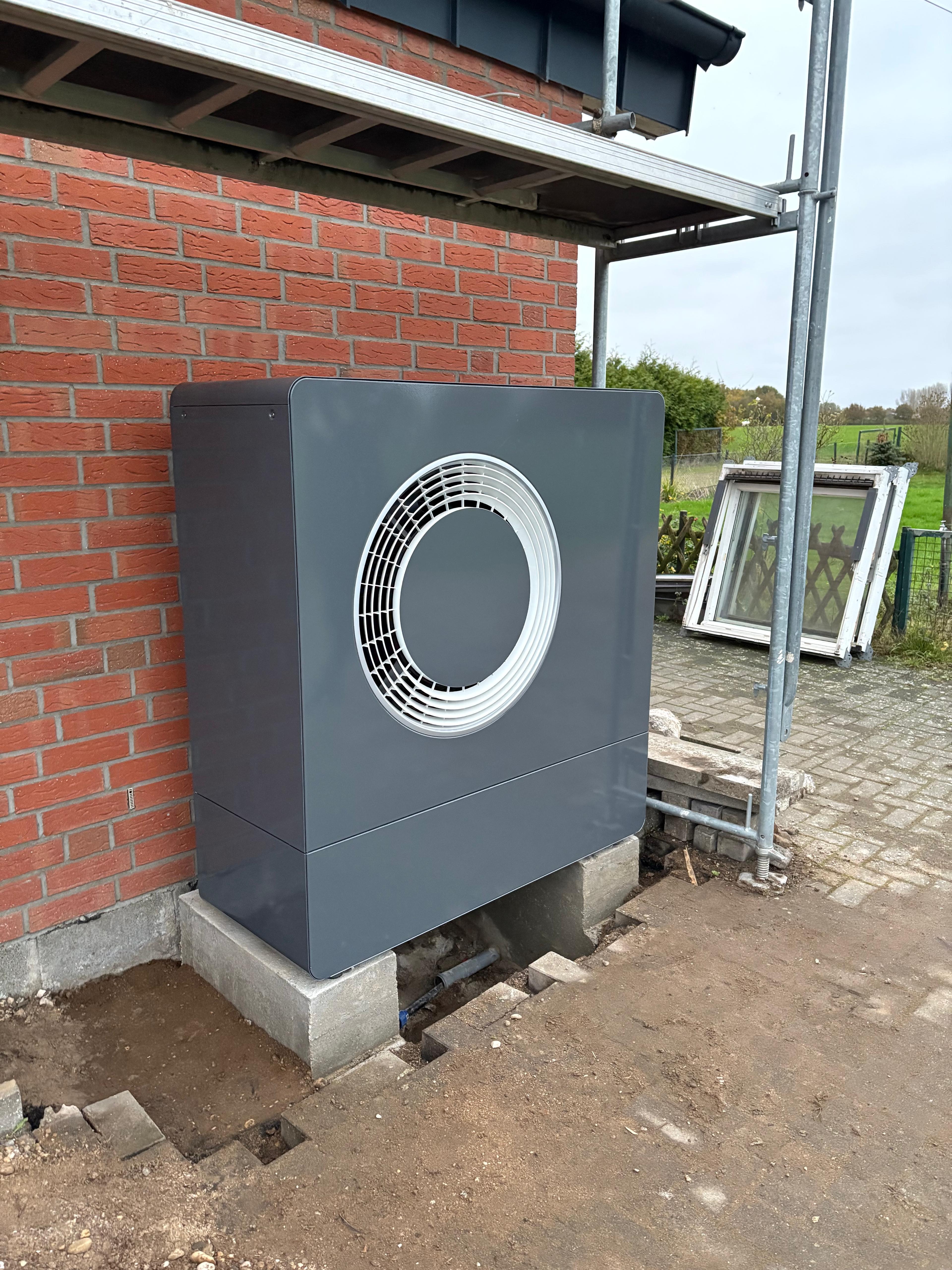 Installiertes Außengerät einer Wärmepumpe an einem Bestandsgebäude